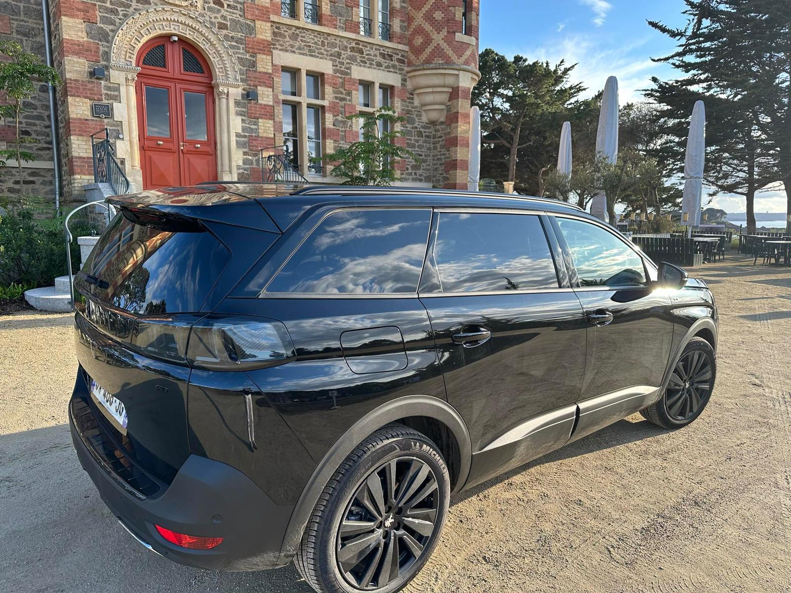 Peugeot 5008 VTC noir élégant devant hôtel de charme à Dinard, service chauffeur premium Bretagne